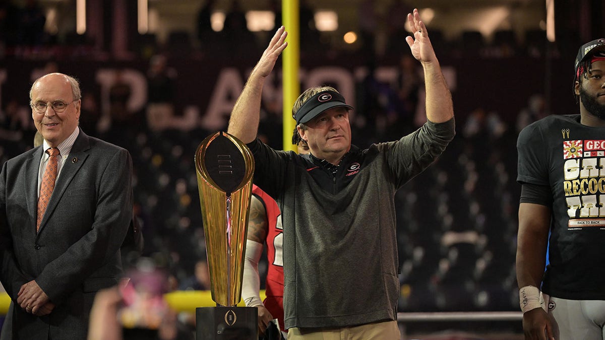 Kirby Smart next to the national championship trophy