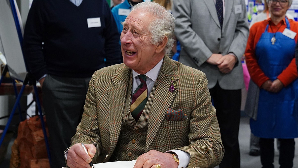 King Charles III appears full of glee while signing a guestbook in Aberdeenshire, Scotland