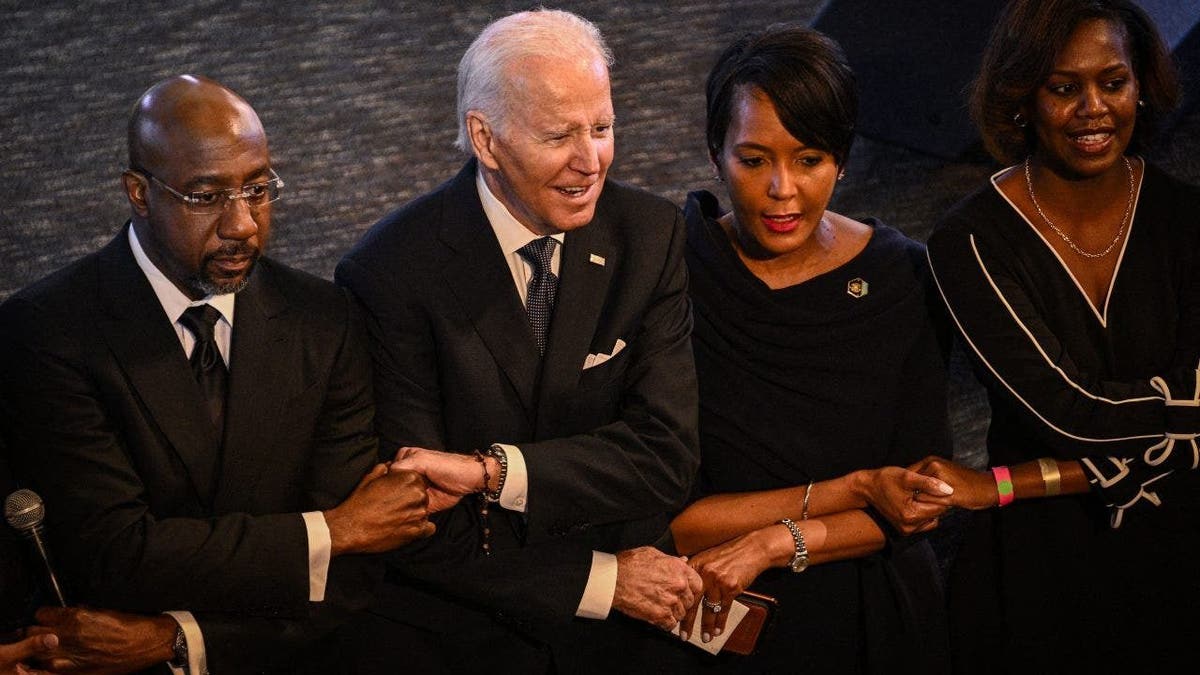 US President Joe Biden holds hands