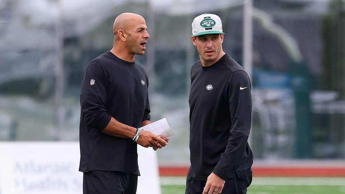 Robert Saleh and Mike LaFleur stand together during training camp