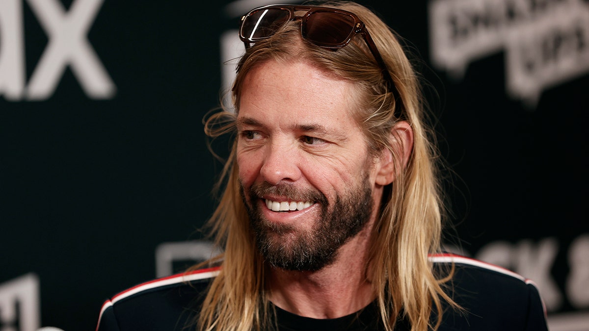 With sunglasses on his head, Taylor Hawkins smiles off camera