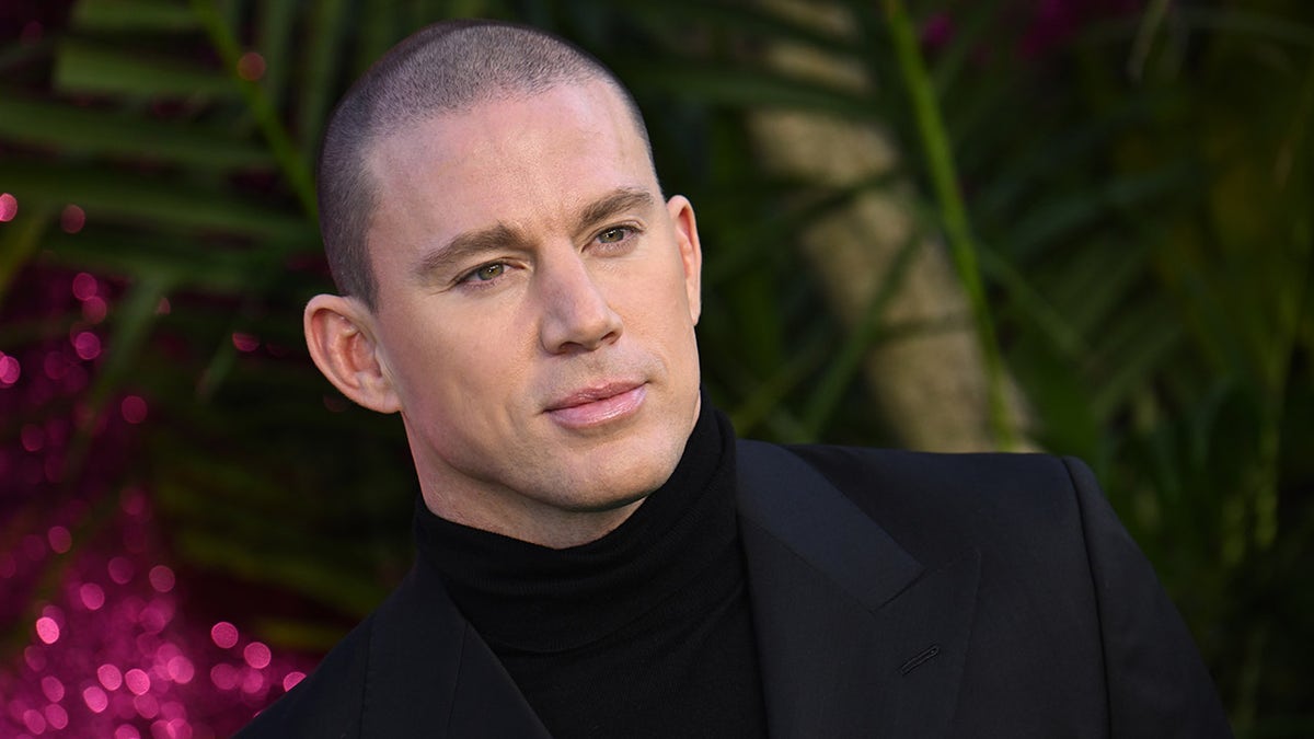Channing Tatum in a black top and black suit with a partially shaved head on the red carpet