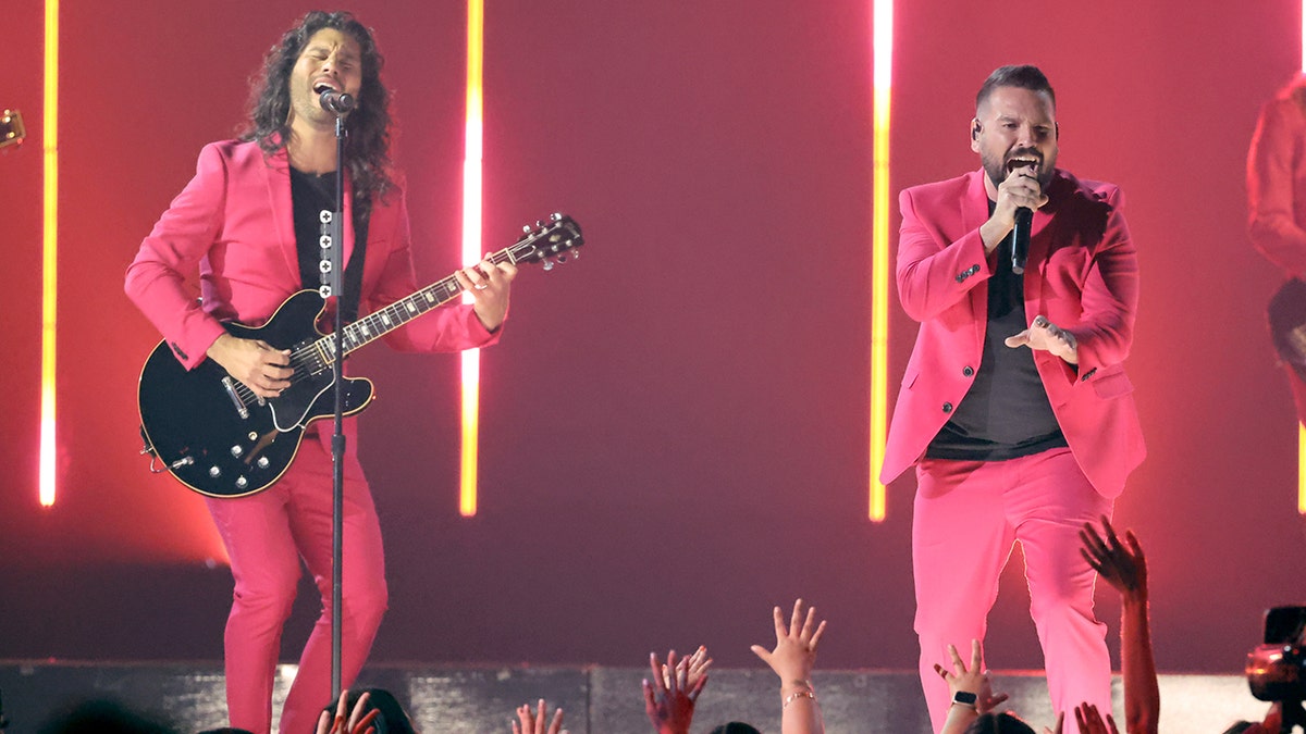 Dan + Shay both wear hot pink suits and black under shirts while performing at the Billboard Music Awards