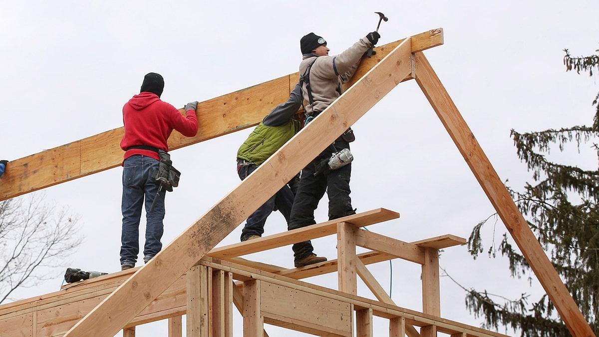 trabalhadores moldam o telhado da casa