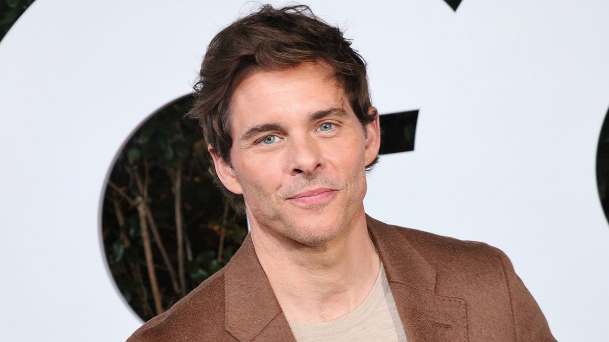 James Marsden on the red carpet in a beige shirt and brown jacket