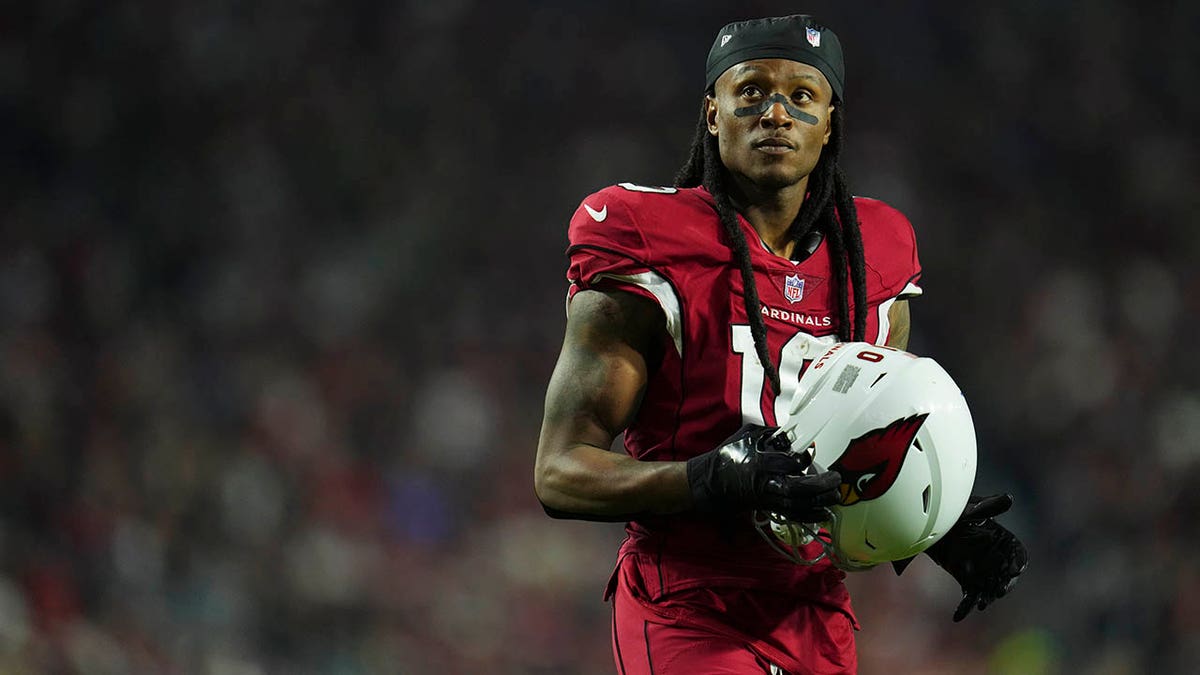 DeAndre Hopkins stands on the field before a game against the Patriots