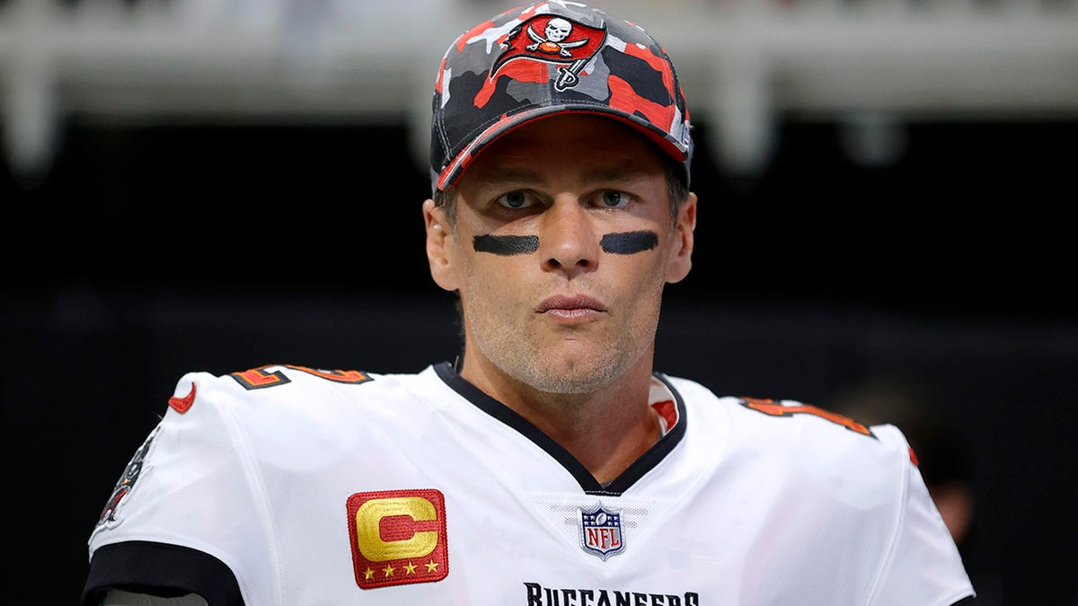 Tom Brady with black eyes and a red camouflage buccaneer hat