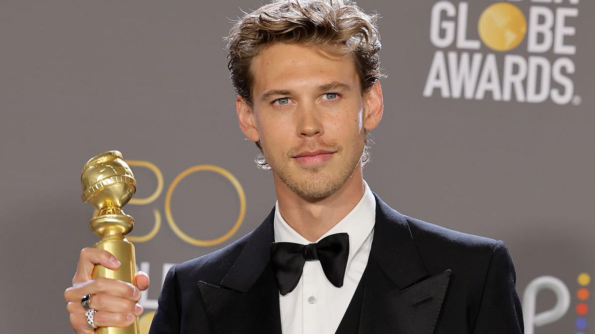 Austin Butler poses with his golden globe