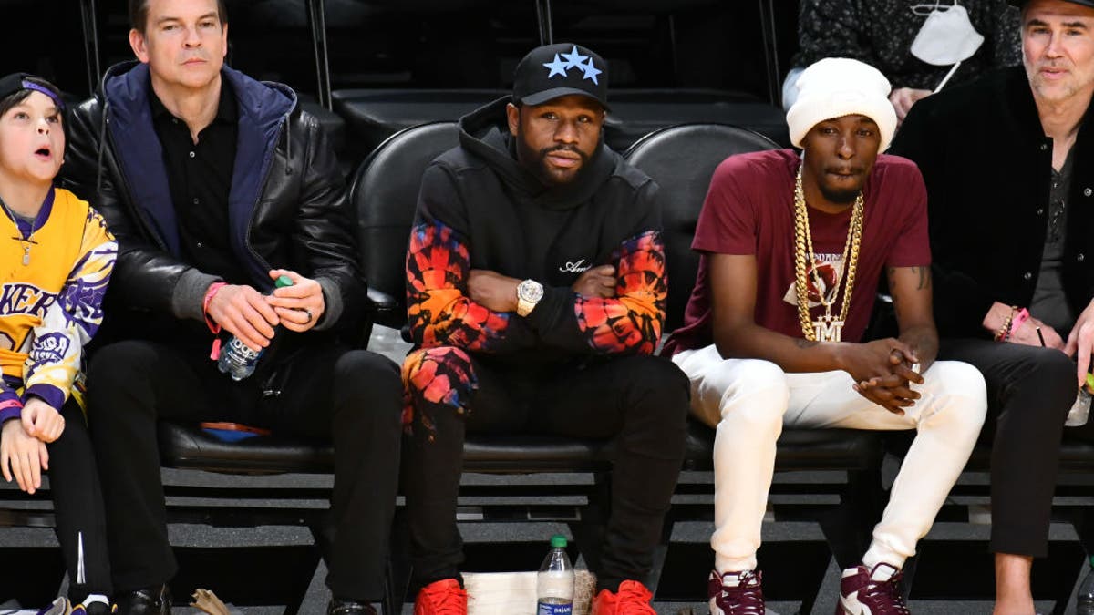 Floyd Mayweather Jr. (C) sits courtside at NBA game