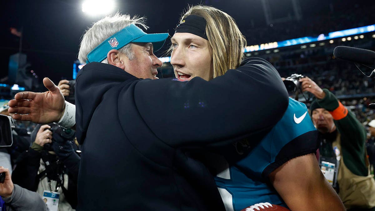 El entrenador Doug Pederson y Trevor Lawrence se abrazan tras la ronda de comodines