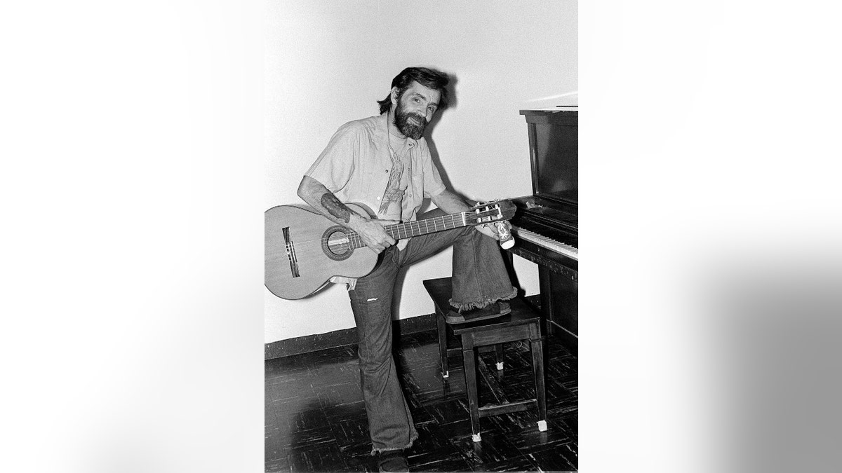 Charles Manson playing a guitar
