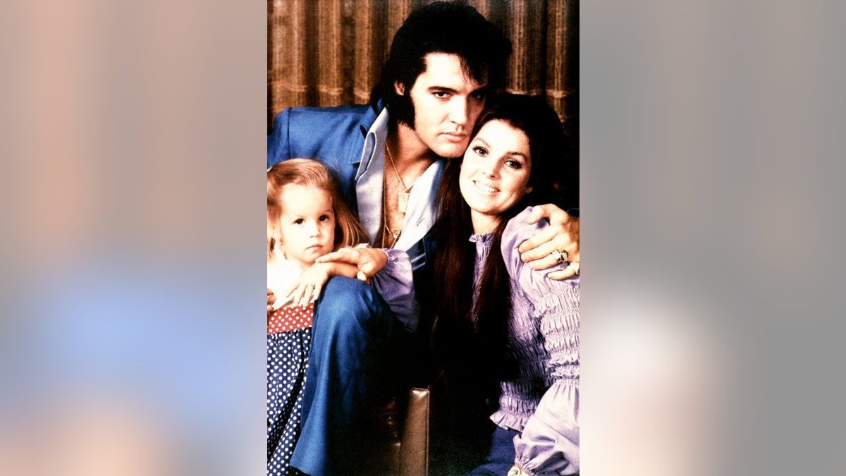 Lisa Marie Presley being embraced by her parents Elvis Presley and Priscilla