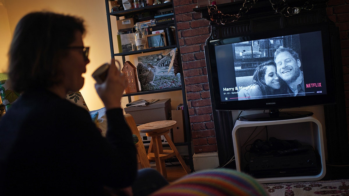 A woman watching 'Harry & Meghan' on Netflix