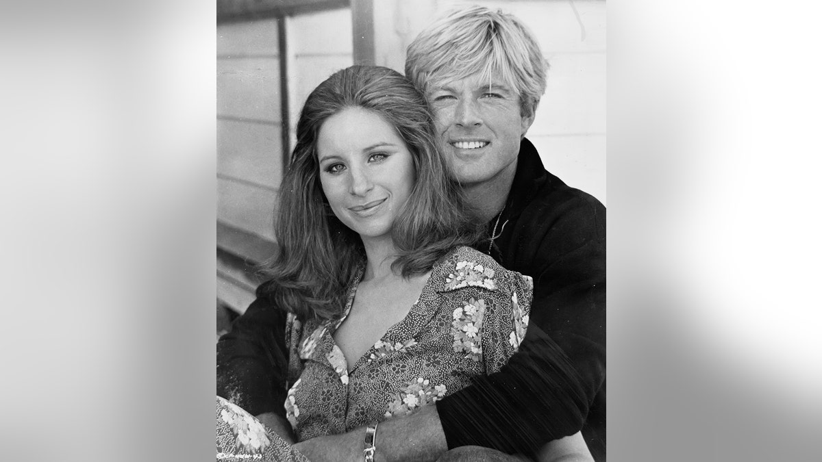 Barbra Streisand and Robert Redford hugging in a promo photo