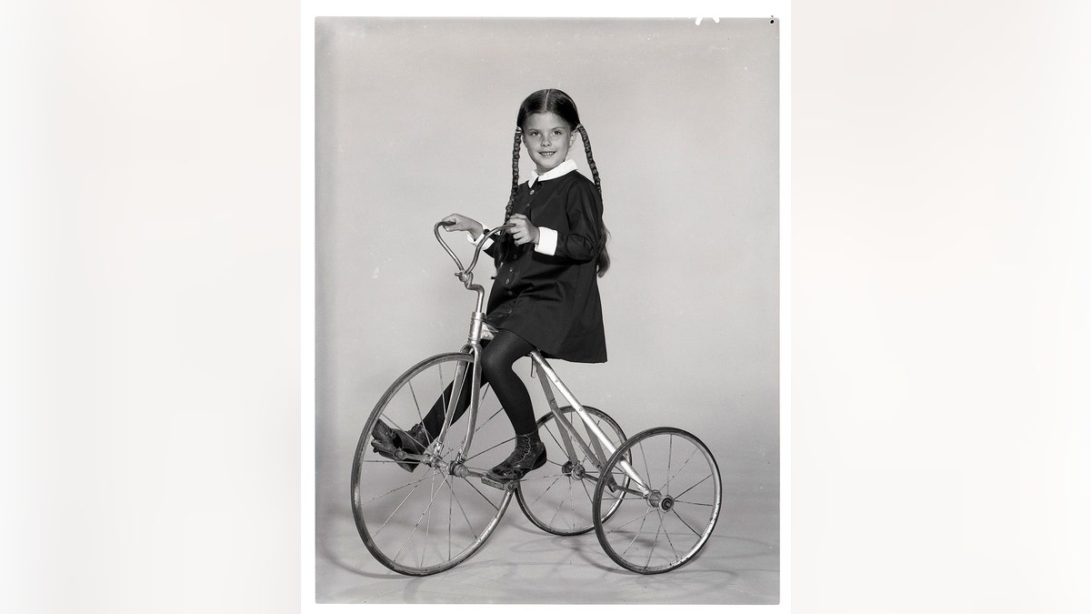 Lisa Loring on a bicycle in 1964 as Wednesday Addams