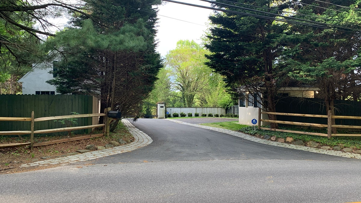 An empty security shack sits outside of a gated home.