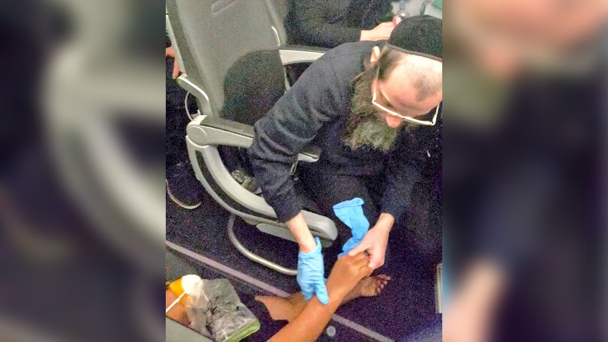 A man helping a woman after she passed out on a flight