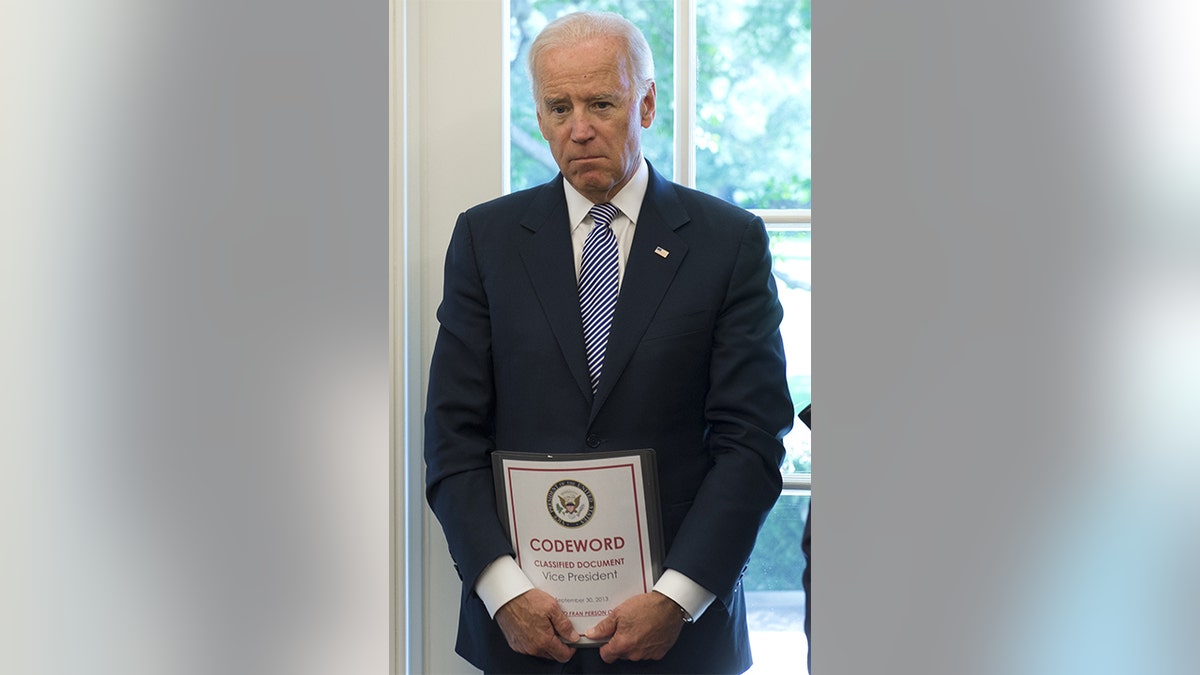 Joe Biden holds a classified document as vice president in 2013