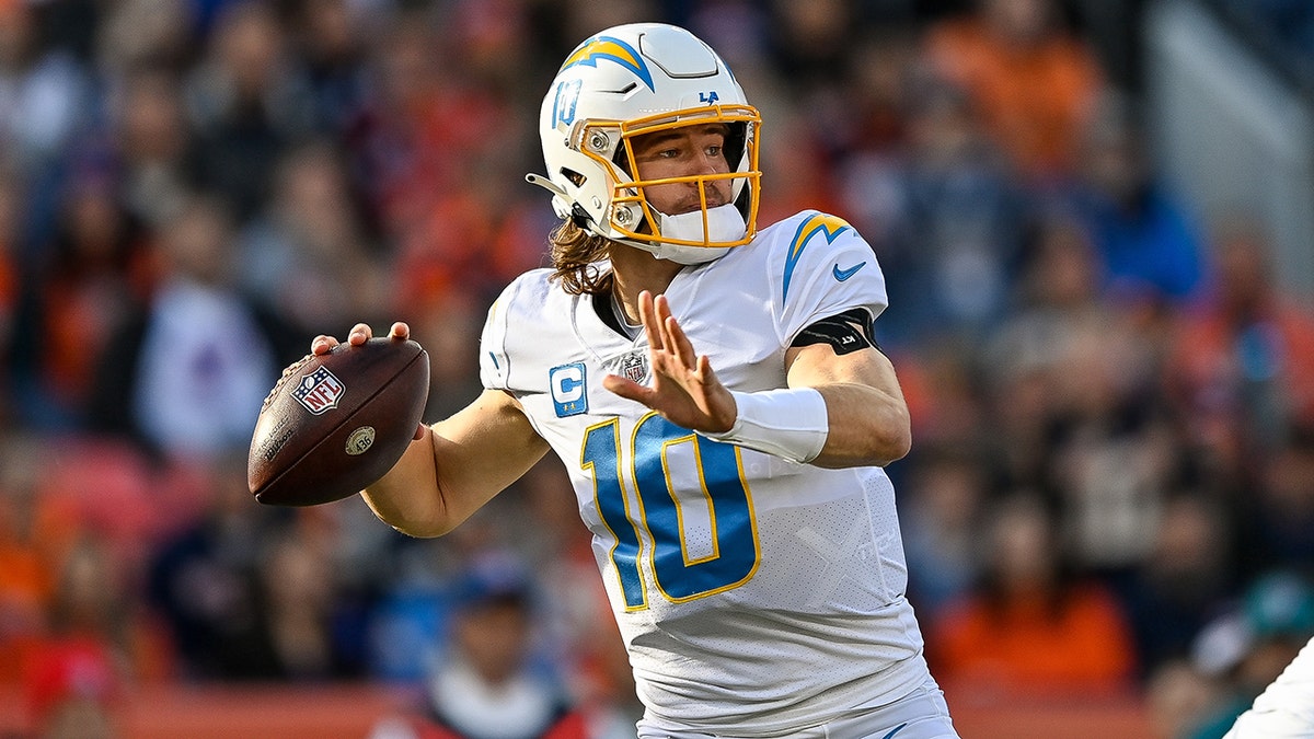 Los Angeles Chargers quarterback Justin Herbert (10) adjusts his helmet as  he warms up before an NFL football game against the Seattle Seahawks  Sunday, Oct. 23, 2022, in Inglewood, Calif. (AP Photo/Marcio