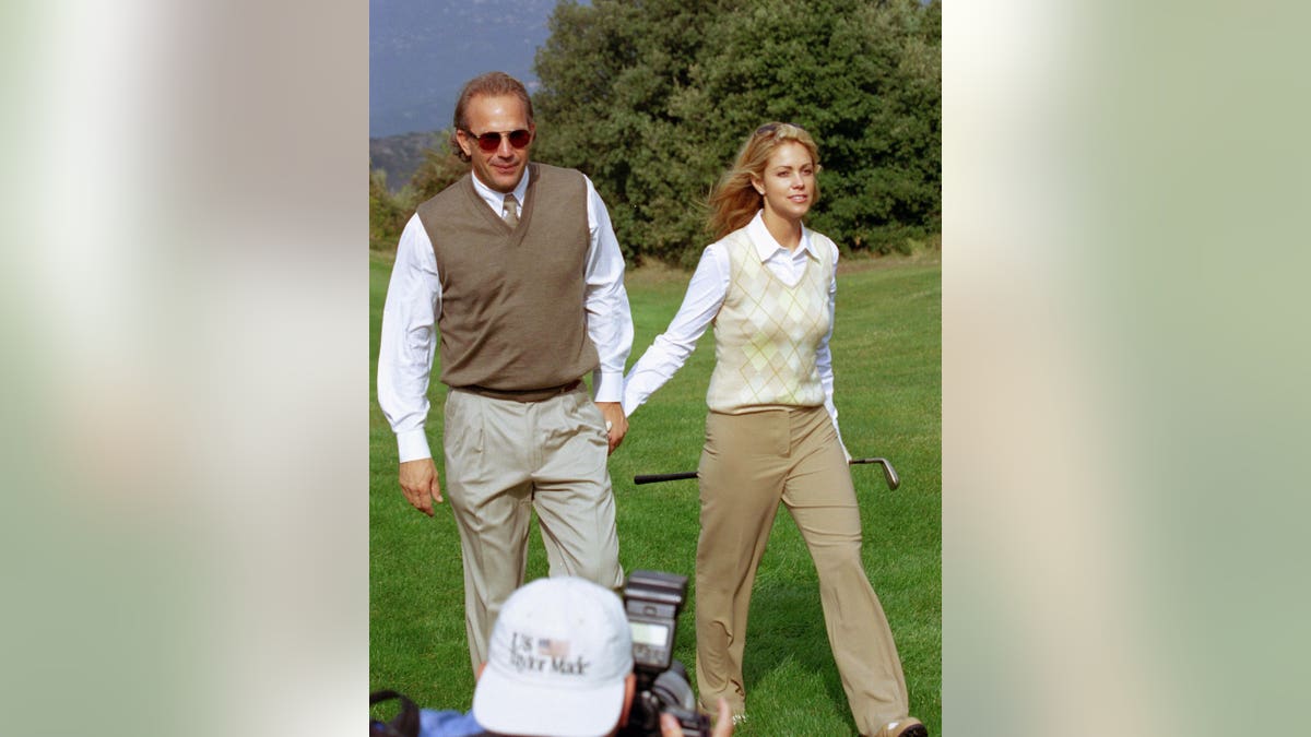 Kevin Costner and Christine during a golf tournament
