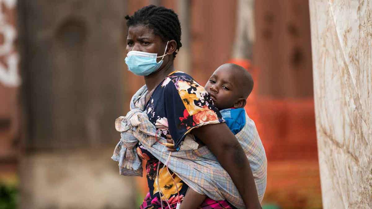 Woman carrying her son with cholera in Malawi