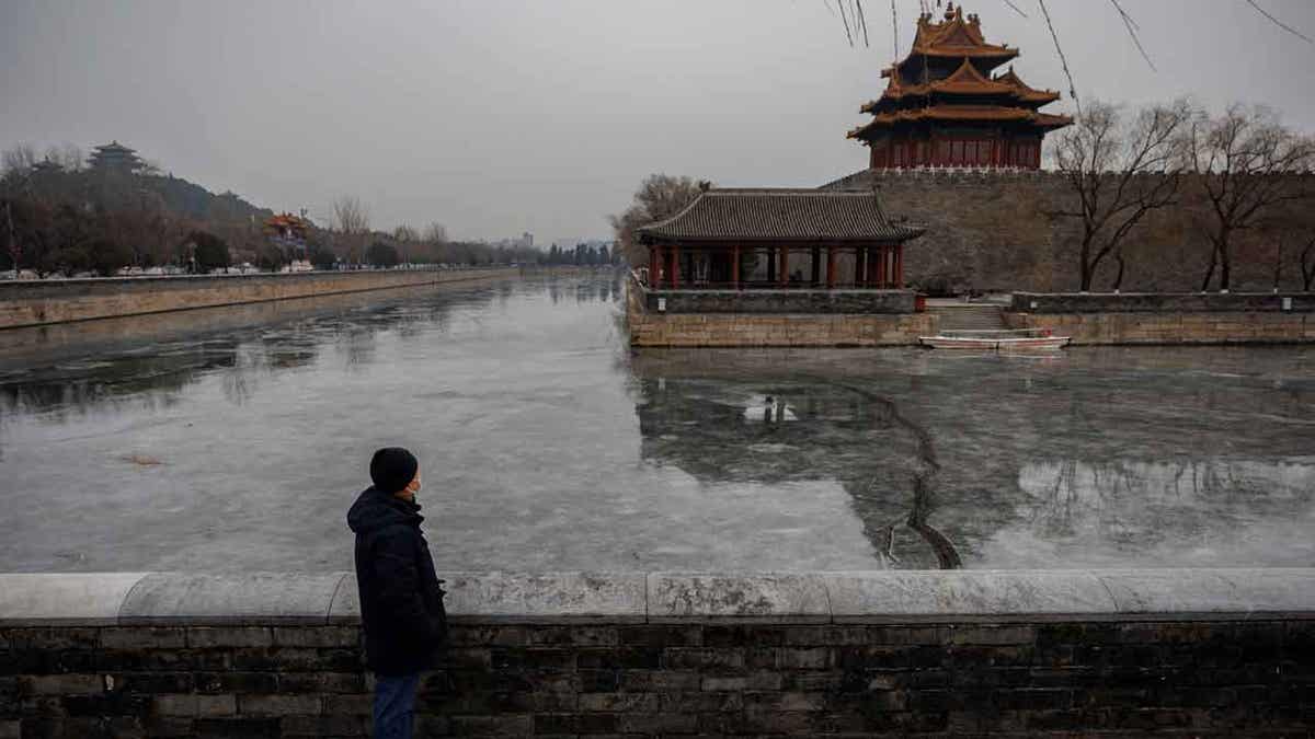 Man standing in China next to building