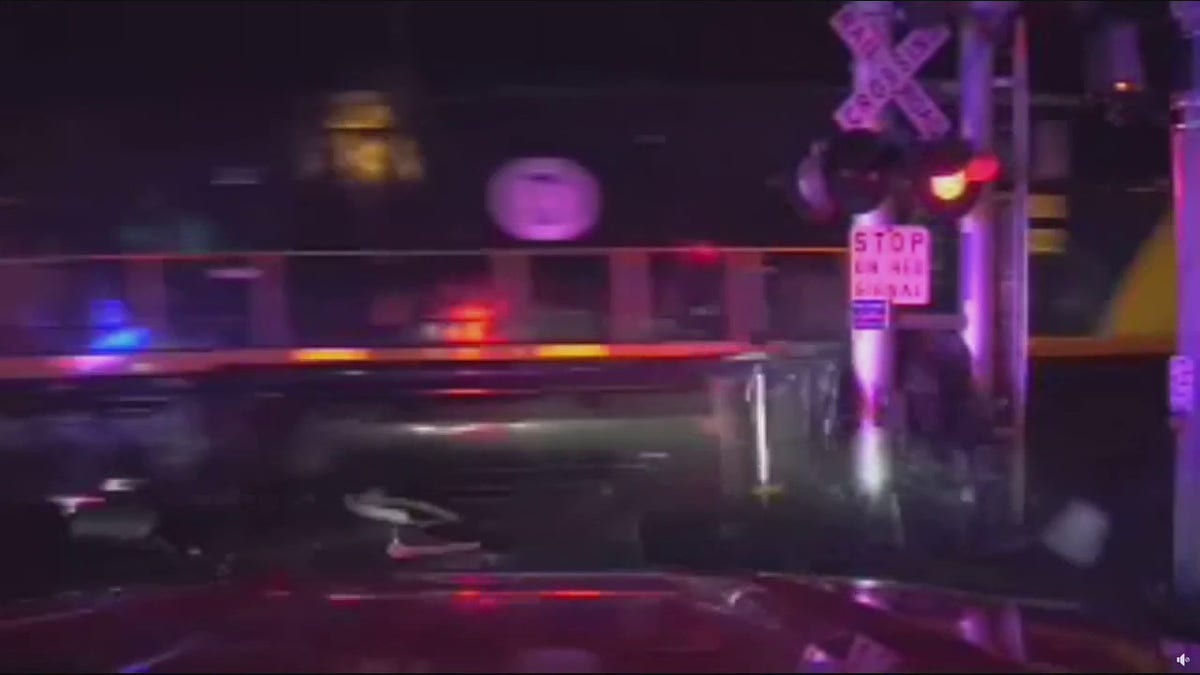 train dragging car into pole