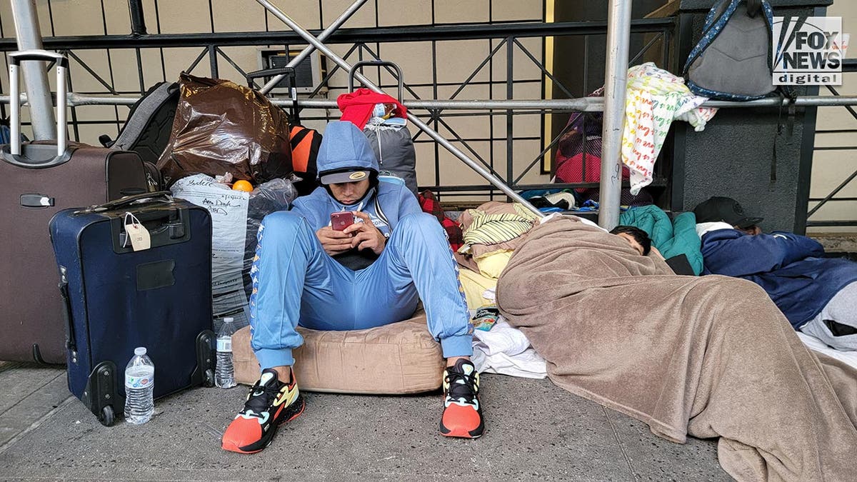 Migrants are seen outside the Watson Hotel in Midtown Manhattan, Monday, Jan. 30, 2023.