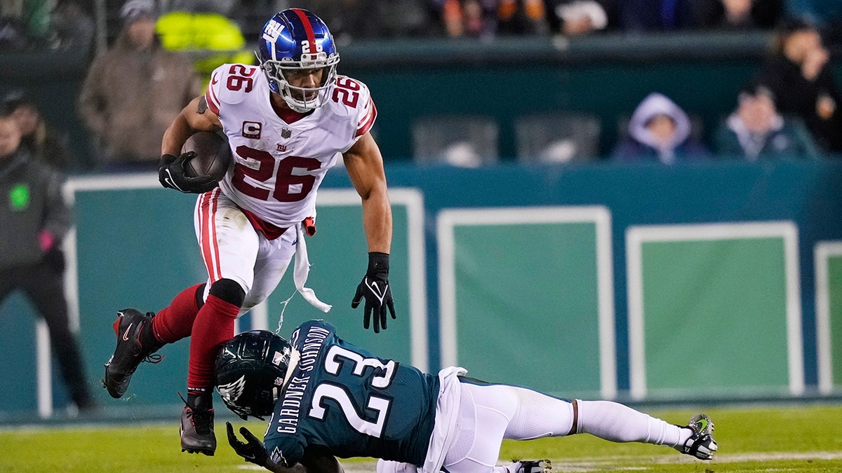 Saquon Barkley runs through a defender