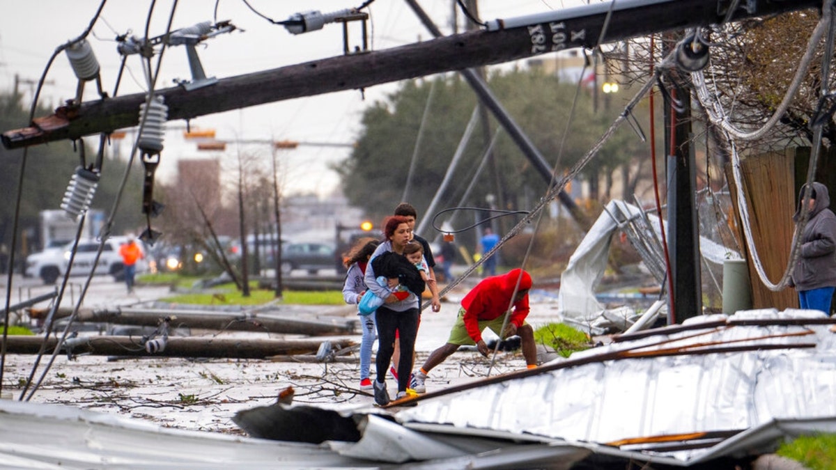 People in Pasadena, Texas, cross under downed power lines