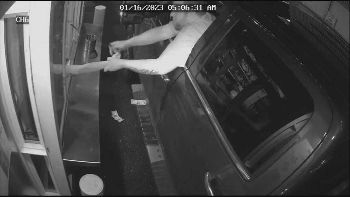 suspect grabbing barista through drive-thru