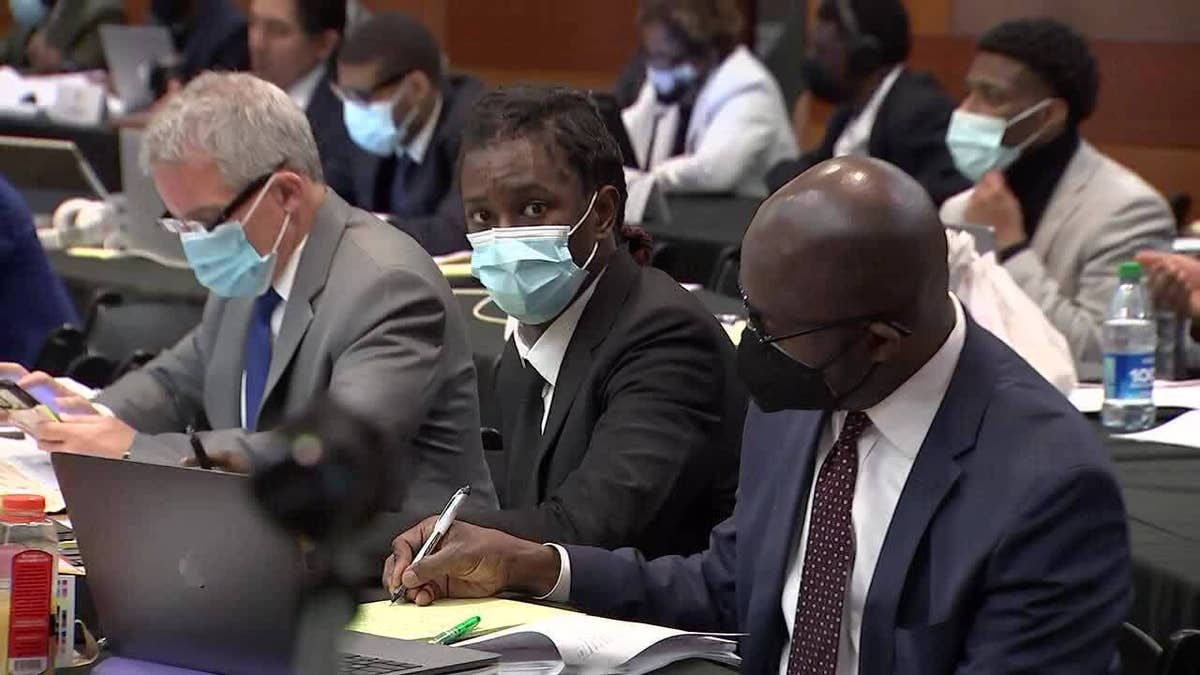 Rapper Young thug sitting at table in court