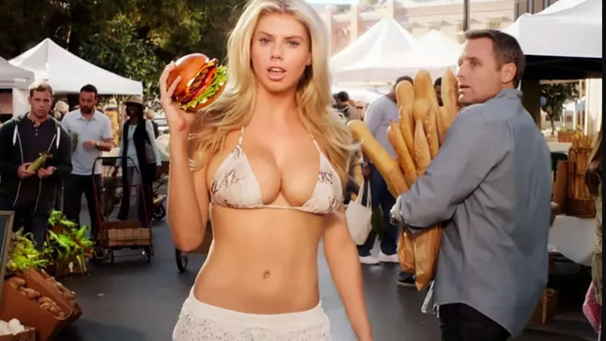 Charlotte McKinney holding a burger for a Carl's Jr. commercial.