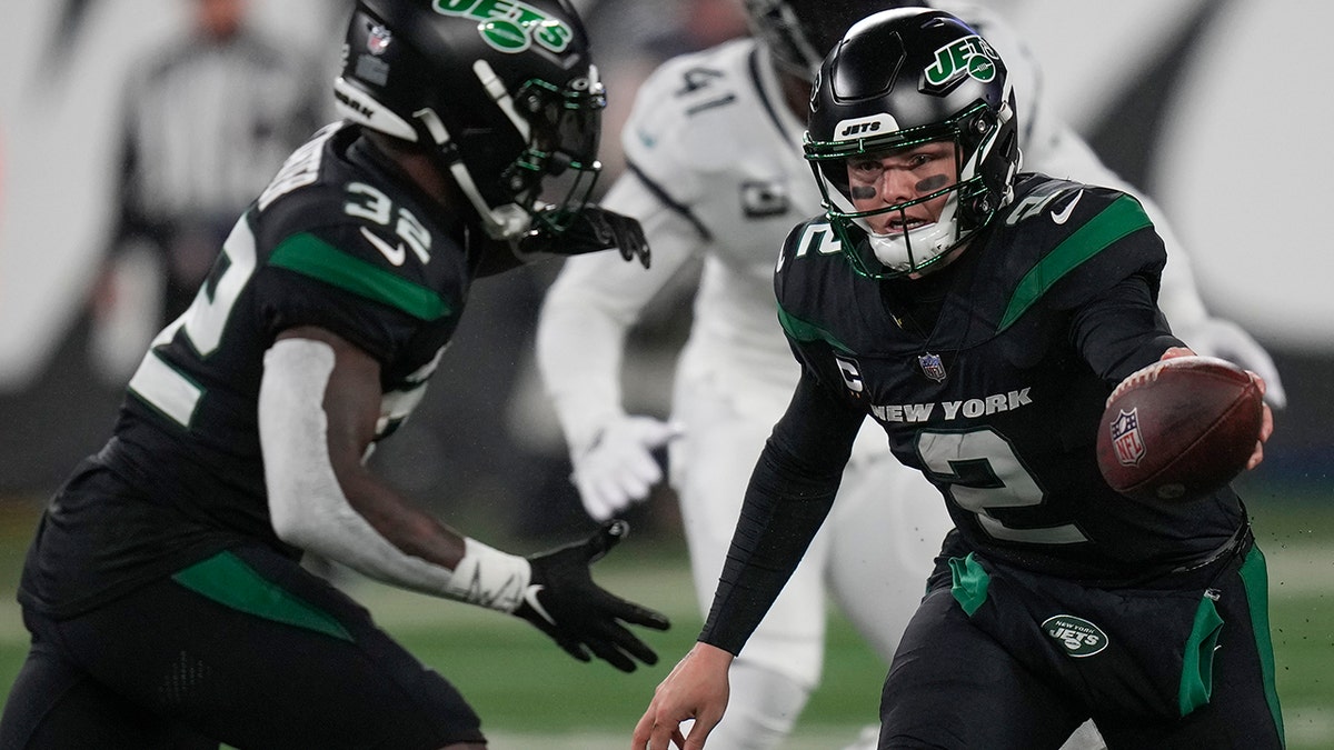 Zach Wilson hands the ball to Michael Carter