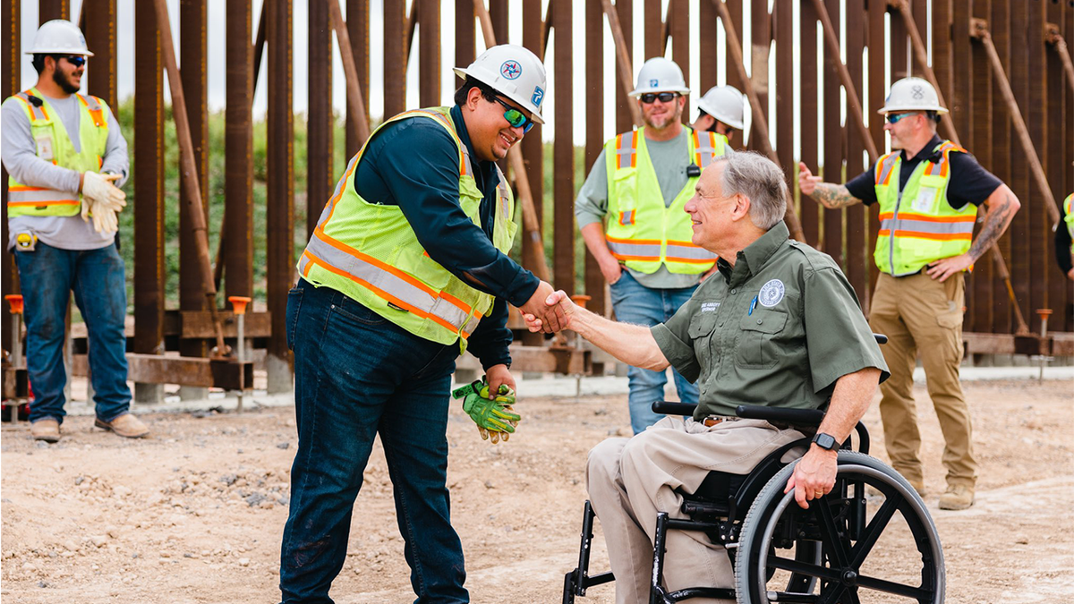 Texas Gov. Abbott shakes hands with man in vest at southern border