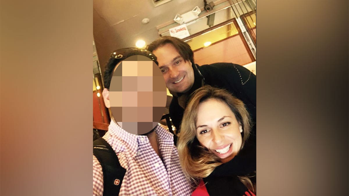 Ana and Brian Walshe take a selfie with friend in a restaurant