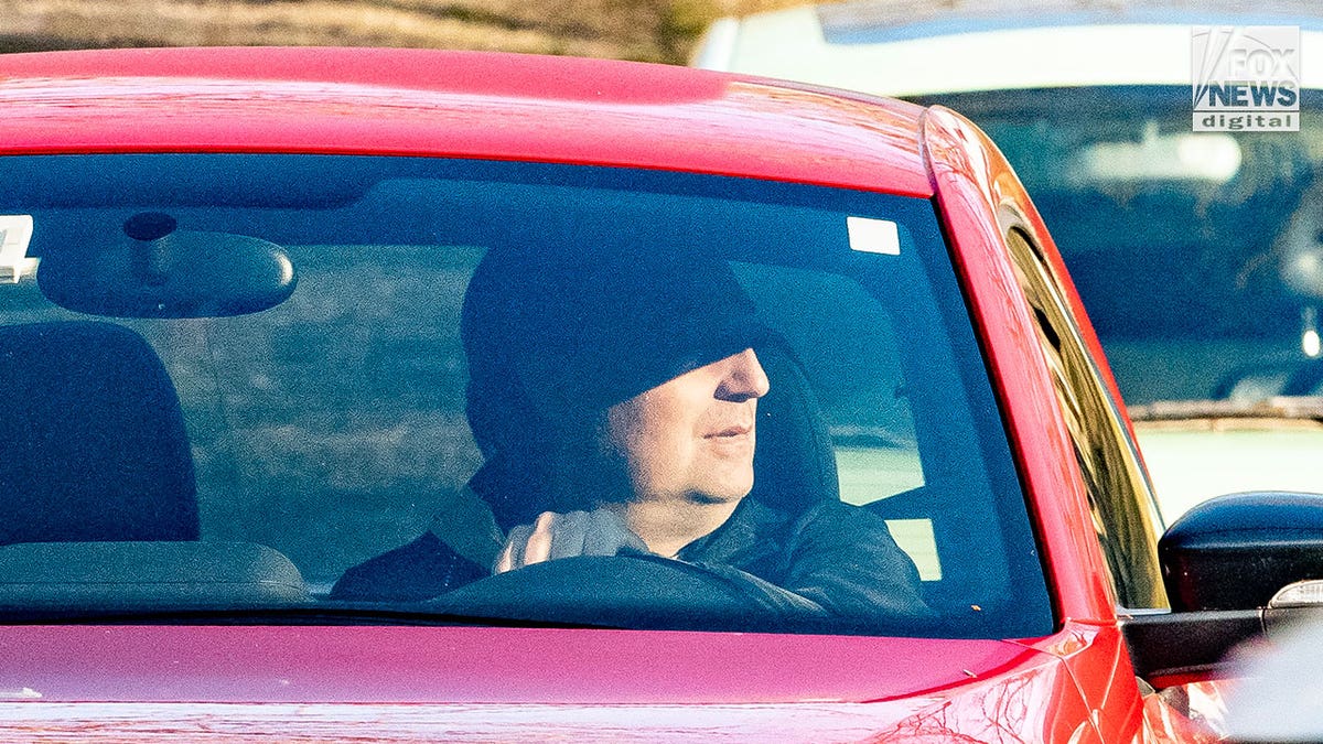 Man who appears to be Brian Walshe drives in red car