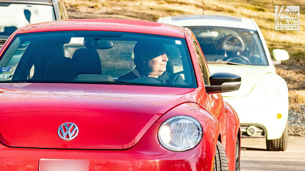 Man who appears to be Brian Walshe drives in red car