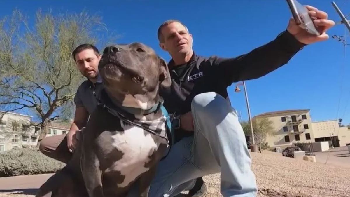 Arizona man taking selfie with another man, dog