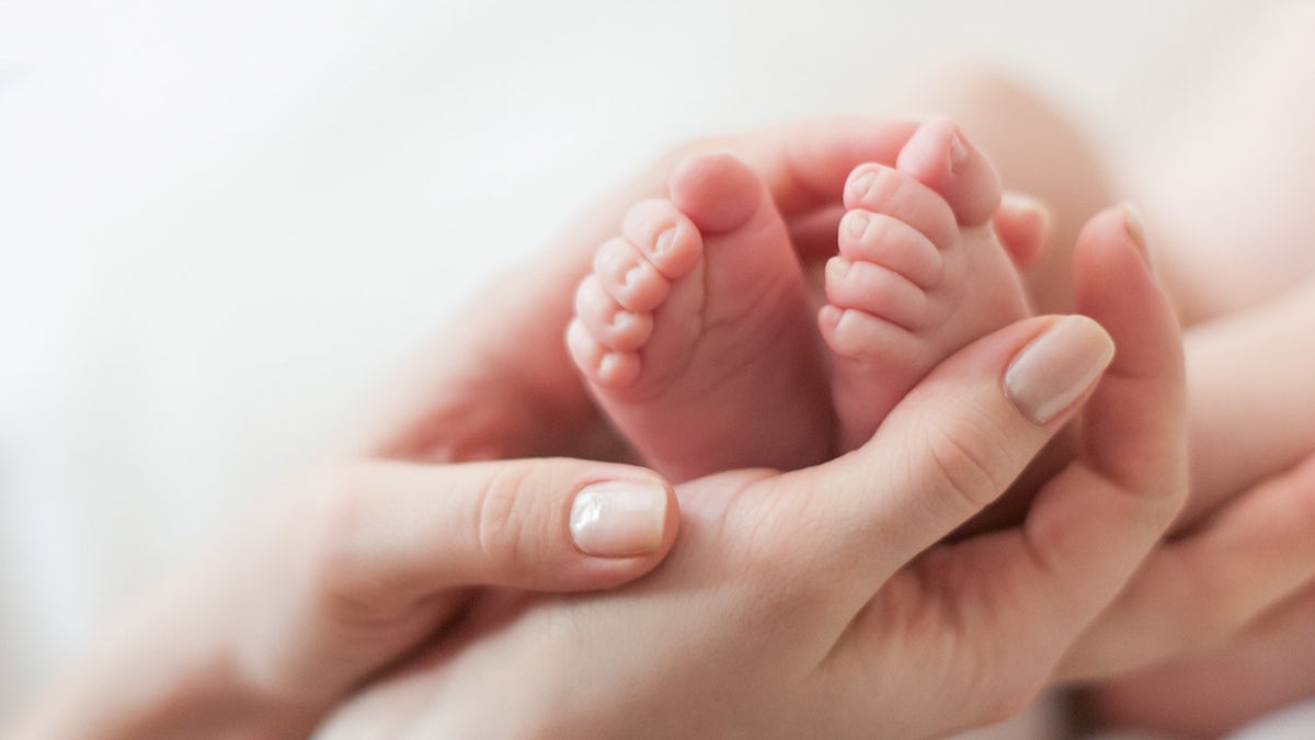baby's feet in mother's hands