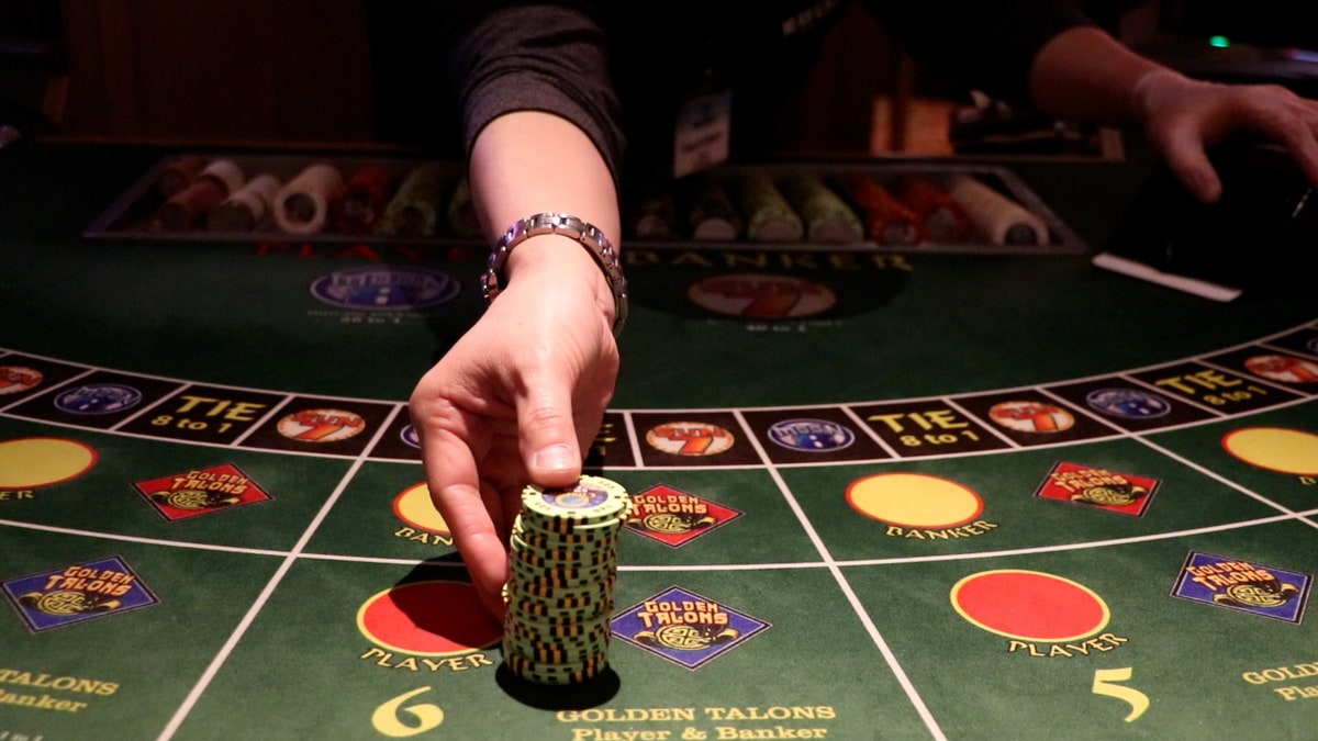 Employee deals chips baccarat table