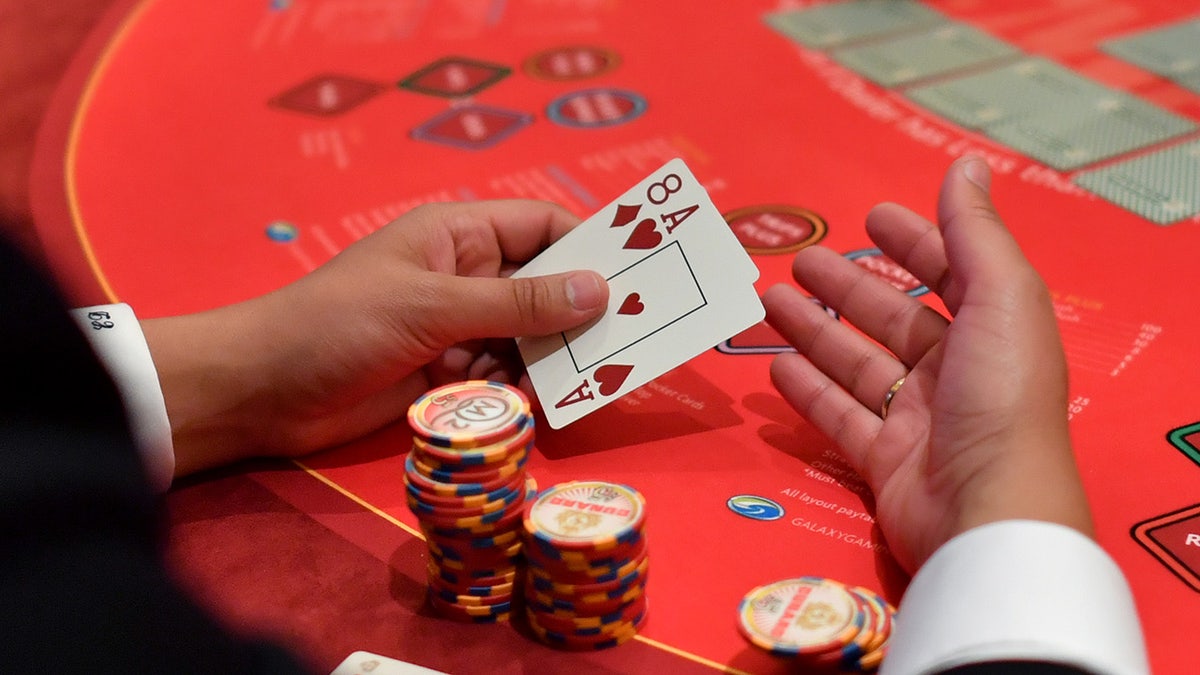 Person holds cards while playing blackjack