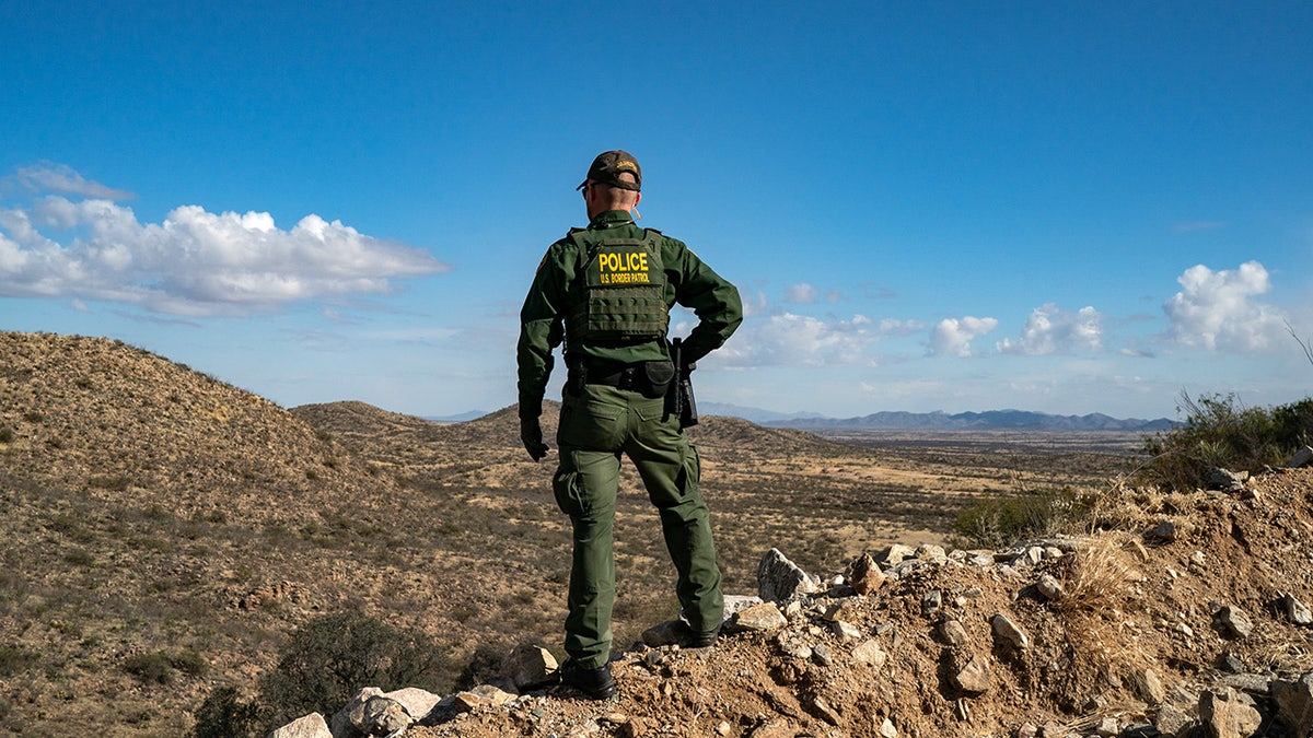 Border Patrol agent stands on a cliff in Arizona