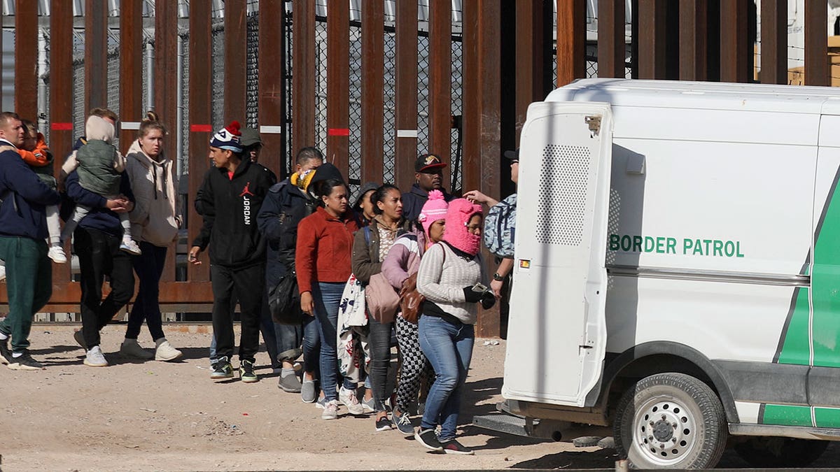 Migrants at border loading into white truck