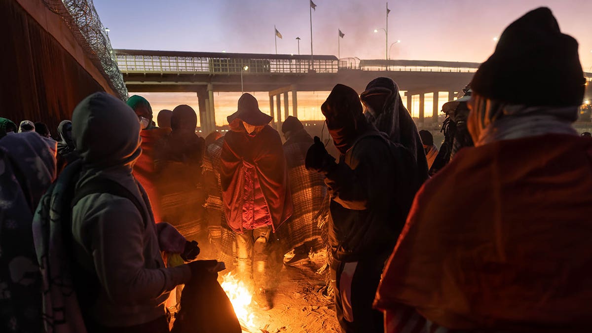 Migrants make fire as sun goes down