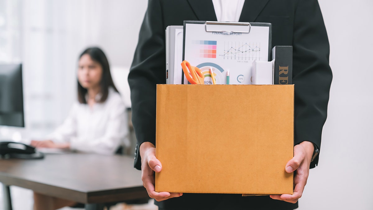 man leaving office with belongings