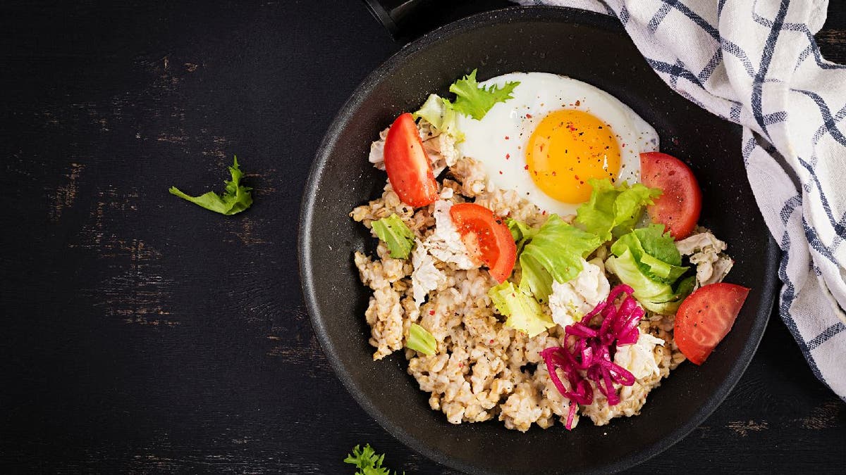 Savory oatmeal with a fried egg, tomatoes and lettuce