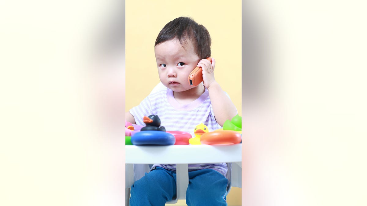 cute baby on toy phone