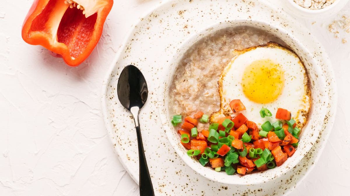 Savory oatmeal with a fried egg, red bell pepper and green onions