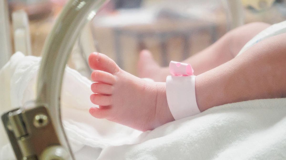 Baby girl with pink hospital anklet